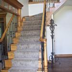 After - This entry staircase update makes a dramatic impact by replacing wood balusters with wrought iron and darkening the floor. Geneva, IL Residence